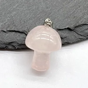 Natural rose quartz crystal mushroom pendant detail shot showing delicate stone carving and polished finish.