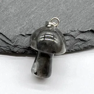 Close-up detail shot of a natural crystal carved mini mushroom pendant with a silver metal bail.