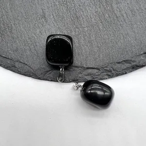 Detail view of black polished stone square pendant, natural crystal necklace accessory.
