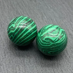 Close-up detail of natural green malachite gemstone sphere showcasing unique vibrant banding.
