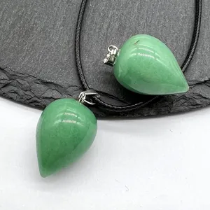 Detailed close-up of green teardrop stone crystal pendant on black cord necklace.