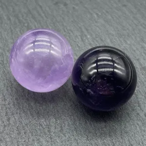 Natural crystal quartz gemstone sphere detail showing polished purple amethyst crystal balls.