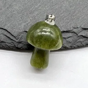 Close-up of a green jade stone mushroom pendant with silver bail, natural gemstone detail view.