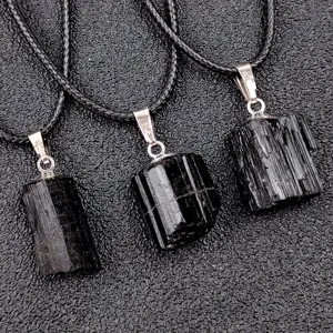 Close up detail of natural black tourmaline rough stone crystal pendant with braided cord.