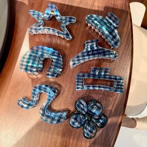 Close up detail of blue plaid resin hair claw clips set featuring assorted geometric shapes.