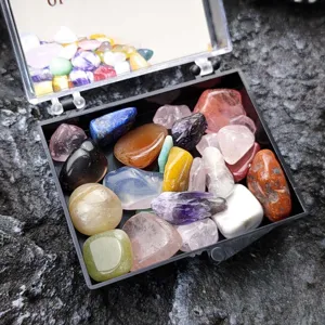 Detailaufnahme von Kristall Mineralien und bunten Trommelsteinen in einer kleinen Box.