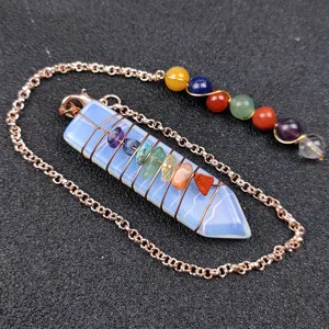 Detailed close-up view of wire-wrapped chakra crystal pendulum with multi-colored stones.