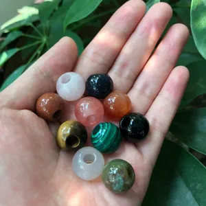 Close-up of colorful natural gemstone beads held in hand, ideal for DIY jewelry crafting.