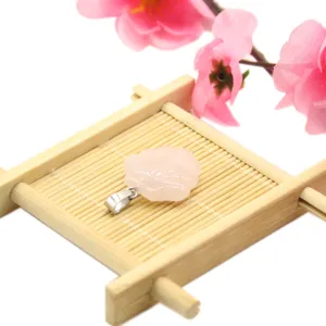 Pink crystal flower carved pendant detail view, lovely DIY jewelry accessory on wood display.