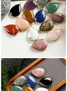 Close-up detail of natural crystal stone teardrop pendants with gold-plated rims for DIY jewelry.