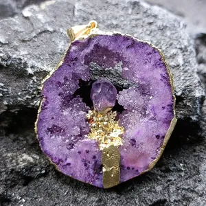 Primo piano dettagliato del ciondolo fetta di geode in agata viola con un bel bordo dorato.