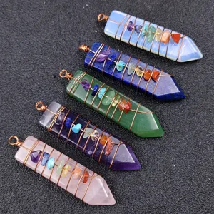 Detail view of natural gemstone crystal arrow wire-wrapped chakra pendulum for yoga.