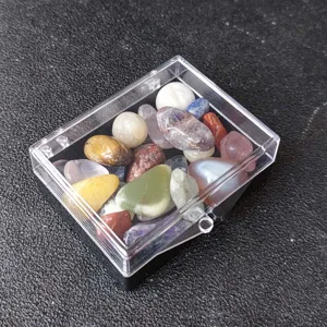Detailansicht von gemischten Kristall-Trommelsteinen Mineralien Proben Set in transparenter Box.