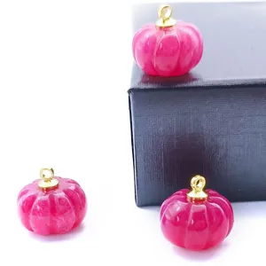 Detailed shot of carved pink jade pumpkin pendant charm with gold loop for DIY jewelry making.