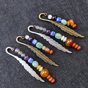 Detail view of vintage feather metal bookmarks decorated with colorful chakra crystal gemstone beads.