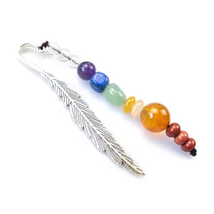 Close-up detail of silver feather bookmark with colorful chakra crystal gemstone beads decoration.
