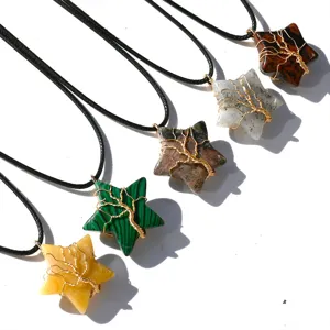 Close-up of natural crystal star pendant necklaces featuring wire-wrapped tree of life design.