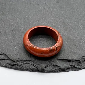 Natural red jasper stone ring close-up detail shot, smooth round gemstone finger ring jewelry.