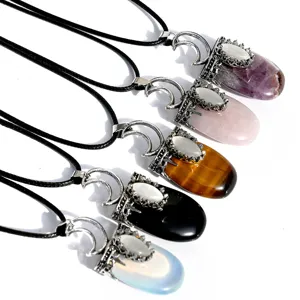 Primo piano di collana con ciondolo piatto in pietra di cristallo naturale con luna e occhio di gatto.