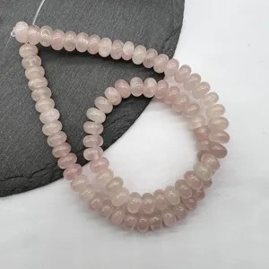 Close-up detail of natural rose quartz abacus beads, polished, ideal for DIY jewelry making.