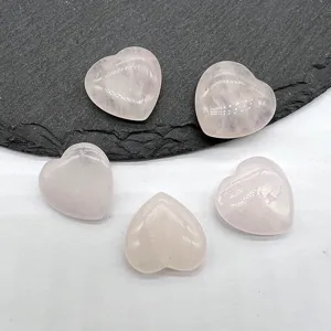 Close-up of polished natural rose quartz crystal heart stones, smooth non-hole peach gemstone decor.