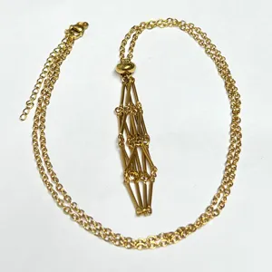 Close-up view of the 18k gold plated stainless steel crystal net cage necklace detail.
