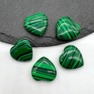 Detailed view of polished green malachite heart-shaped crystal stones, smooth and natural texture.