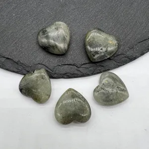 Detailed view of natural crystal heart shaped gemstone pendants, polished non-perforated healing stones.