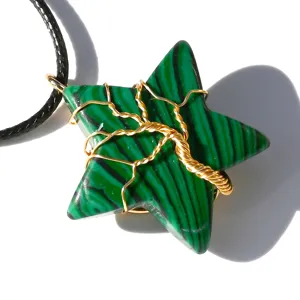 Close-up detail of green crystal star pendant with gold wire tree of life wrap necklace.