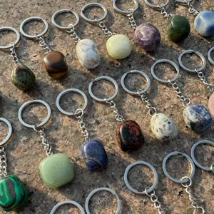 Natural crystal tumbled stone keychain detail view, assorted gemstone metal pendant.