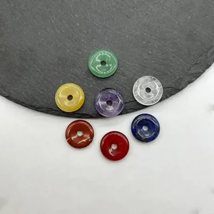 Detailed view of colorful natural crystal stone donut pendants, ideal for DIY jewelry making.