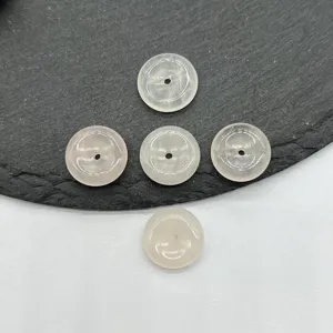 Vue de détail en gros plan de boucles de paix en quartz rose naturel, texture polie lisse.