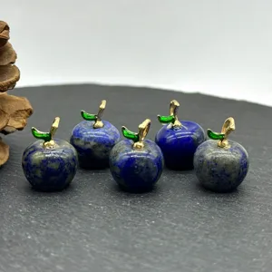 Detail view of gemstone apple pendants with gold stems and green leaves for DIY jewelry design.