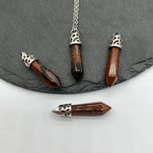 Detaillierte Nahaufnahme von Naturstein sechseckigen Saeulen Kugel Anhaenger Schmuck.
