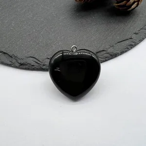 Black heart-shaped natural stone pendant detail, smooth polished gemstone jewelry accessory.