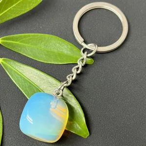 Stainless steel keychain with polished blue gemstone pendant, closeup detail shot.