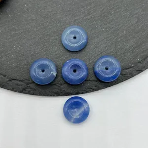 Gros plan de perles donut en cristal bleu de 15 mm, accessoires de bijoux en pierres précieuses.