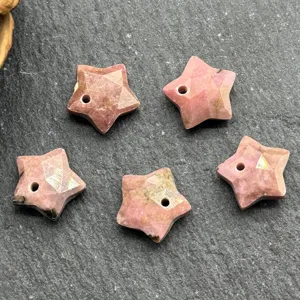 Faceted pink star stone pendant detail shot, drilled star bead component for DIY jewelry making.