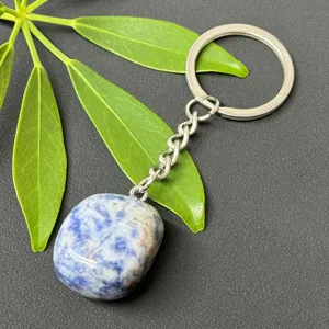 Close-up of polished natural crystal stone pendant and stainless steel keychain detail.