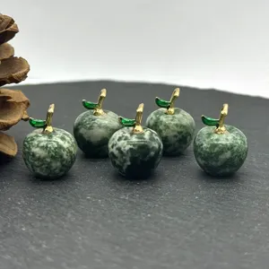 Close-up of 5 green natural stone apple charms with gold stems for DIY jewelry making.