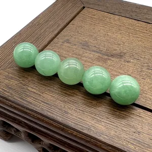 Detailed close-up view of 10mm non-hole green gemstone round beads displayed on wooden base.