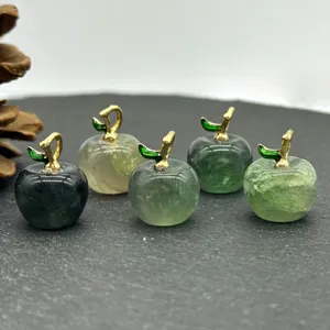 Close-up detail of small crystal apple pendants with gold stems, gemstone DIY jewelry components.
