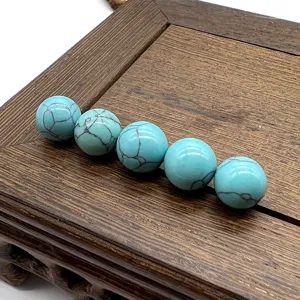 Close-up detail of smooth turquoise spotted stone round beads, undrilled DIY jewelry material.