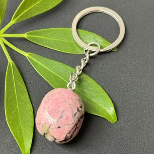 Close-up detail of a polished natural pink crystal stone keychain with stainless steel ring.