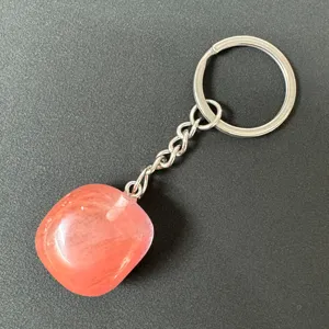 Detailed close-up of a pink crystal tumbled stone keychain with stainless steel ring and chain.