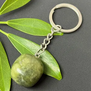 Detail shot of natural green crystal tumbled stone pendant keychain with stainless steel hardware.
