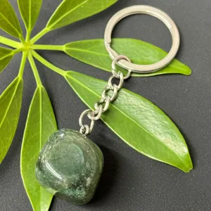 Close-up detail of natural green crystal tumbled stone keychain with durable stainless steel ring.