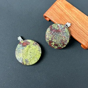 Detailaufnahme eines runden Edelstein-Anhängers mit einzigartiger grün-roter Textur und Öse.