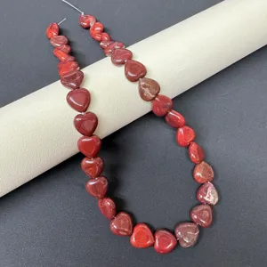 Close-up detail of natural red heart gemstone beads strand, perfect for DIY jewelry making.