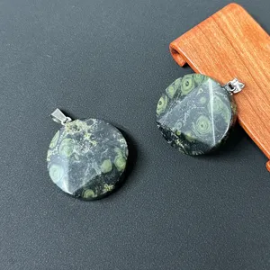 Detailansicht von runden Naturkristallstein-Anhängern mit Metallösen und facettiertem Design.